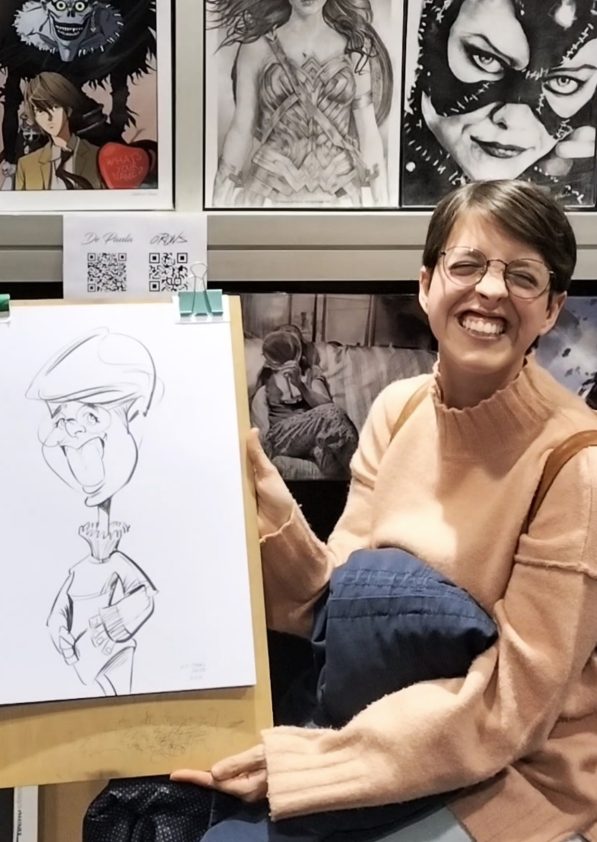 Foto de una chica sonriente mostrando su caricatura.