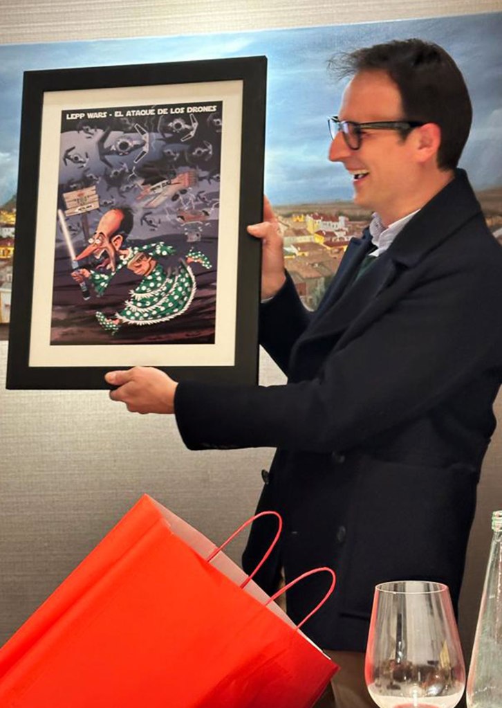 Hombre sonriente mirando y mostrando su caricatura personalizada a color.