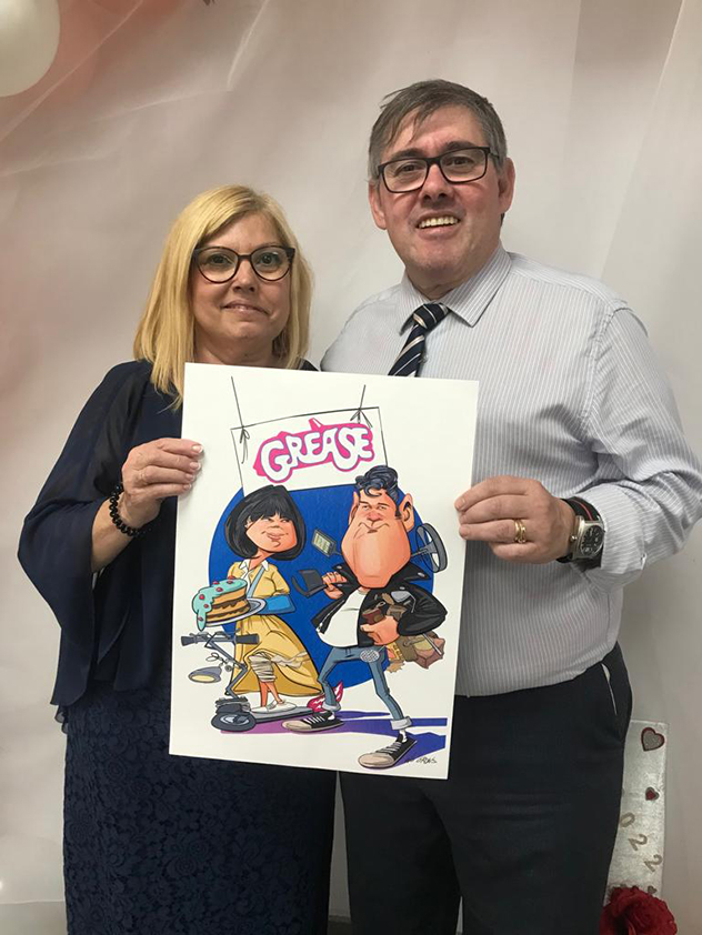 Pareja posando con su caricatura personalizada.