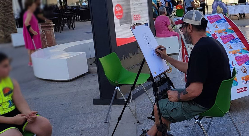 "Dibujante haciendo caricaturas en la vía pública"